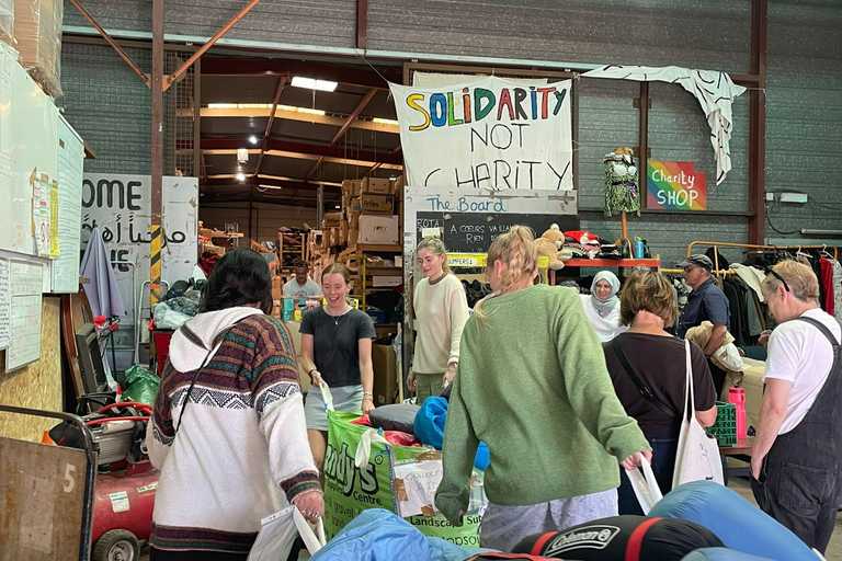 A group of volunteers putting away donated items into a warehouse space