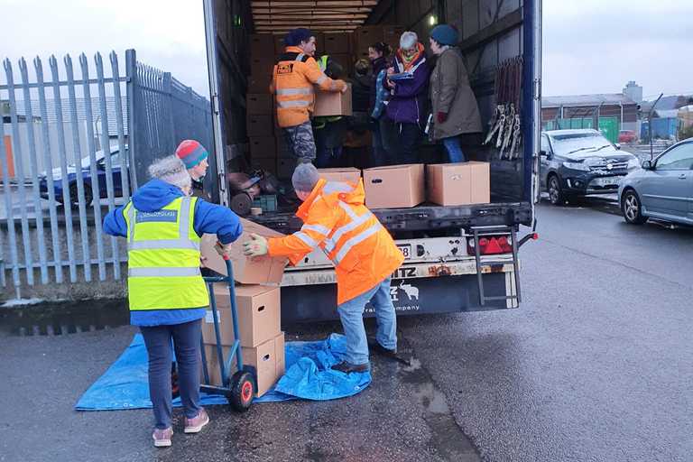Volunteers loading a truck of boxes of aid items