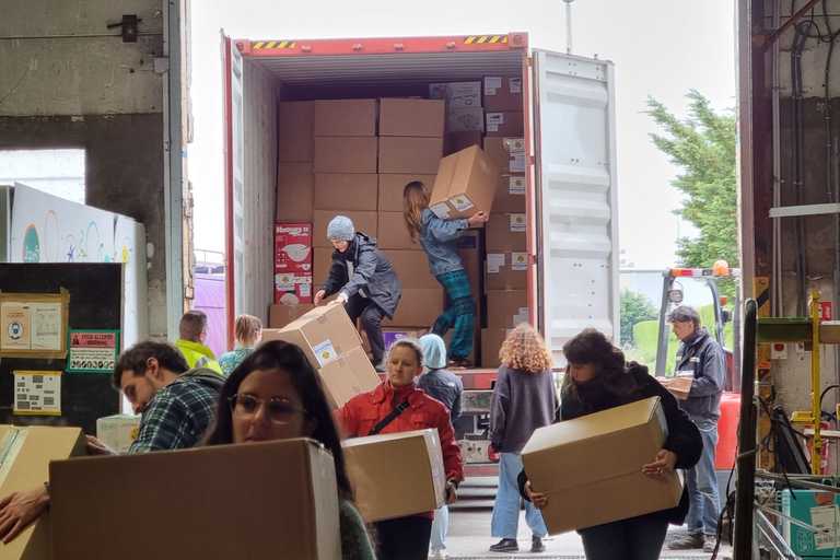 Volunteers unloading boxes of aid from a truck